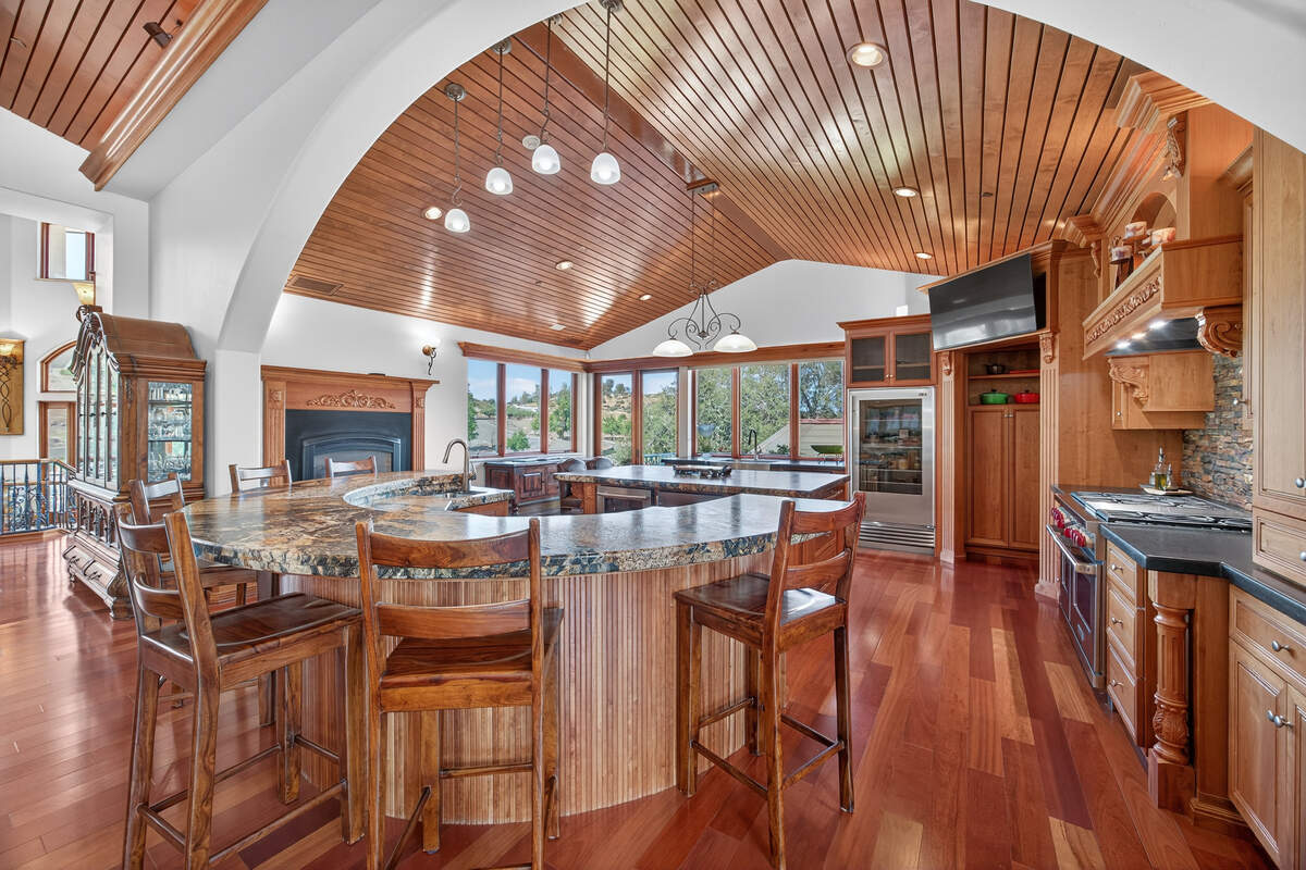 The kitchen in the El Dorado Hills estate features custom cabinetry and finishes consistent with the home’s broader craftsmanship, including cherrywood, carved mahogany and extensive stonework.